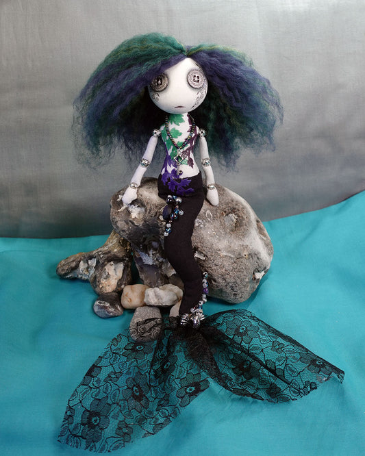 a button eyed Gothic mermaid doll in deep blues purples and greens, with beaded lace tail