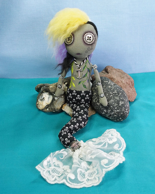 a nonbinary cloth merrow merfolk art doll with button eyes and non binary pride flag hair