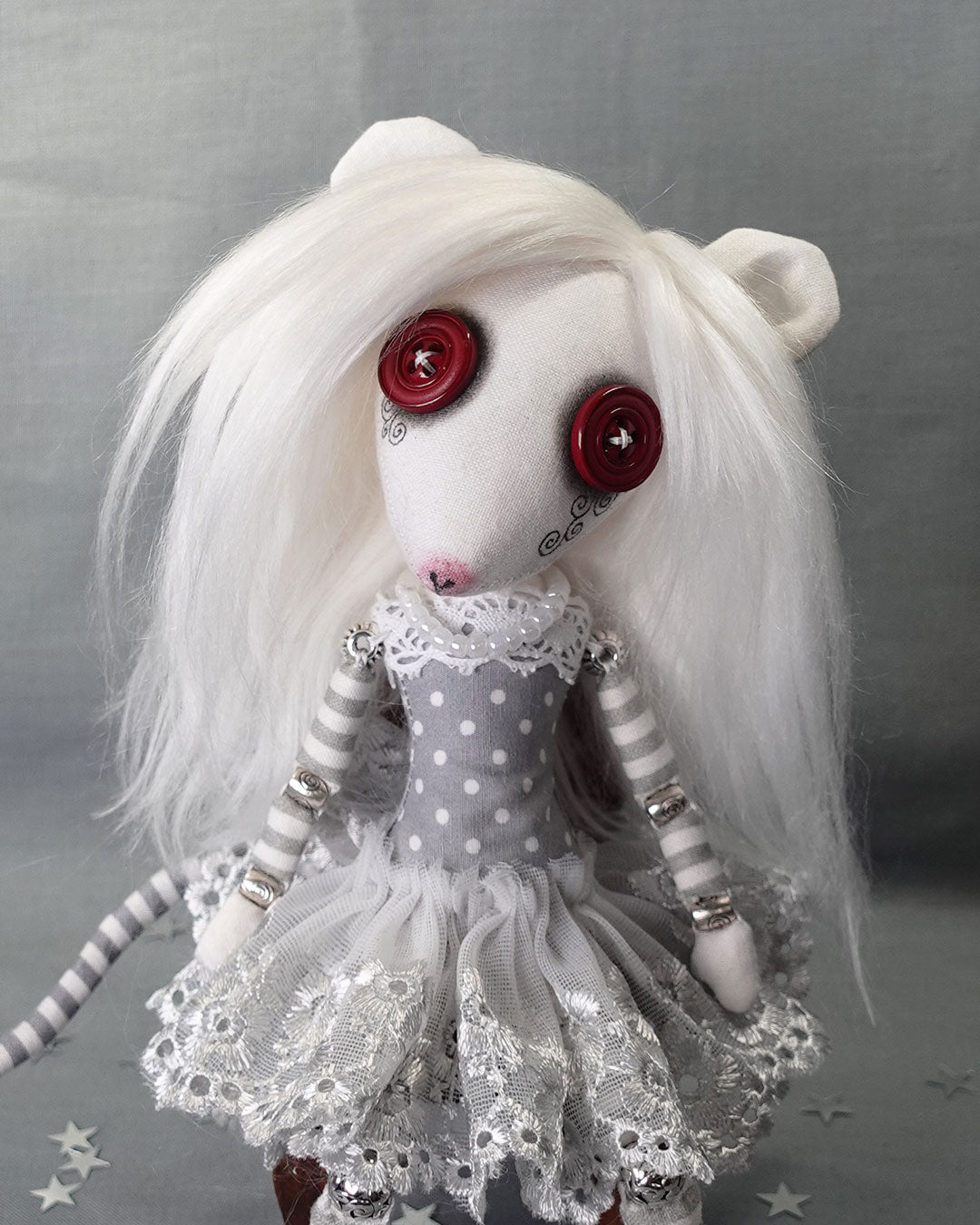 an albino rat cloth art doll with red button eyes and long white hair