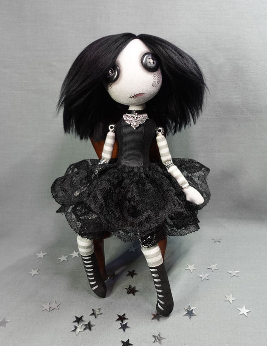 a button eyed goth girl doll with black hair and black lace dress