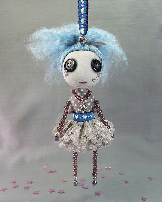 a hanging button eyed art doll with blue hair and purple glass beaded limbs