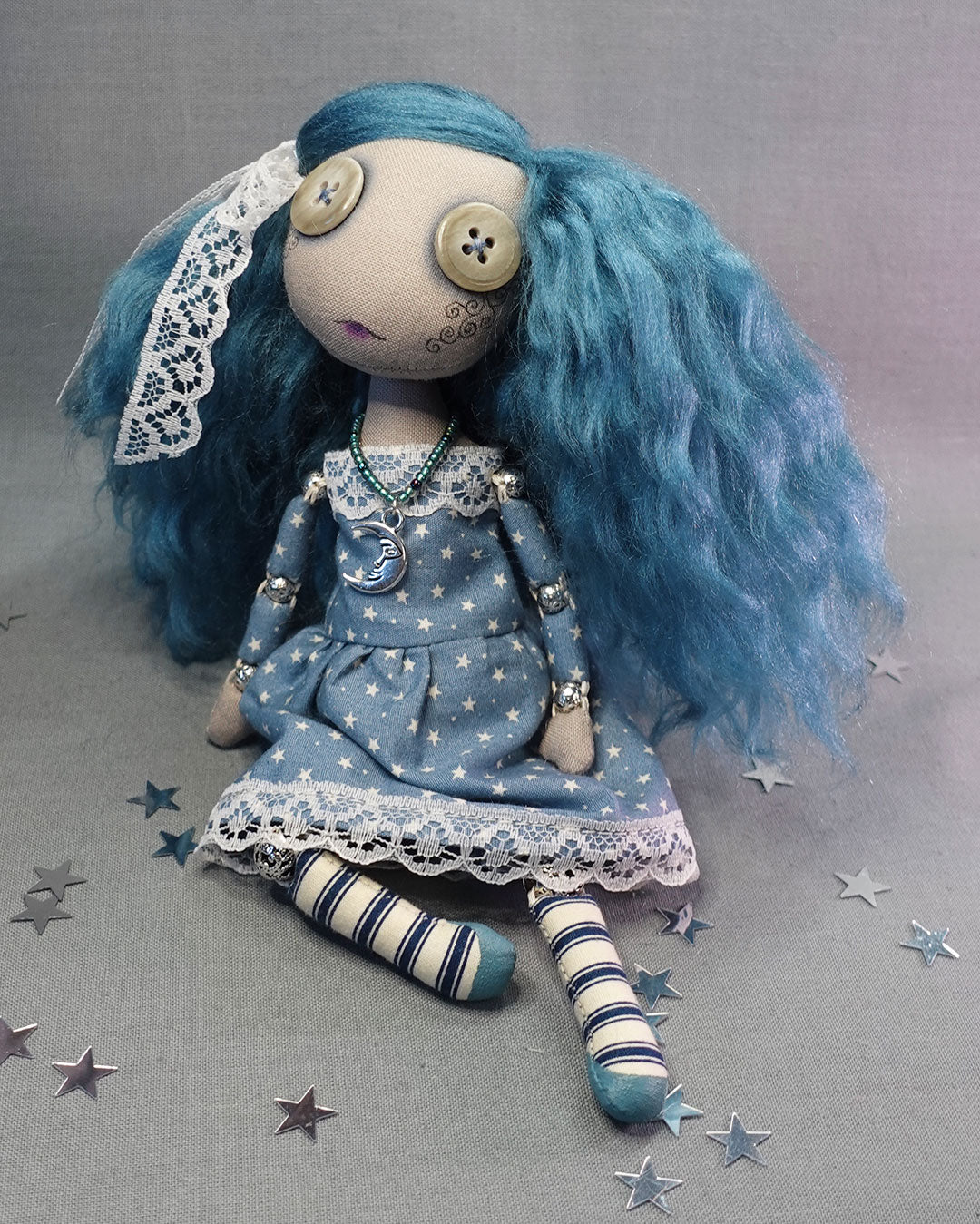 a button eyed cloth art doll with blue hair in star print dress