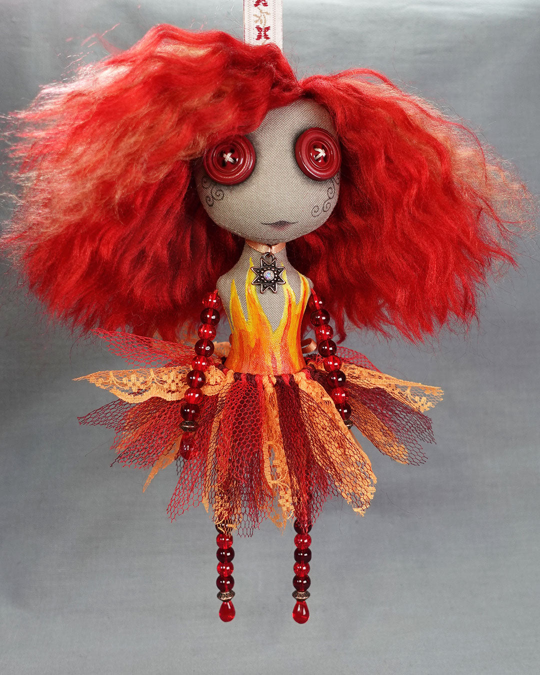 hanging fire spirit art doll in reds and oranges with red glass beads and flame detail
