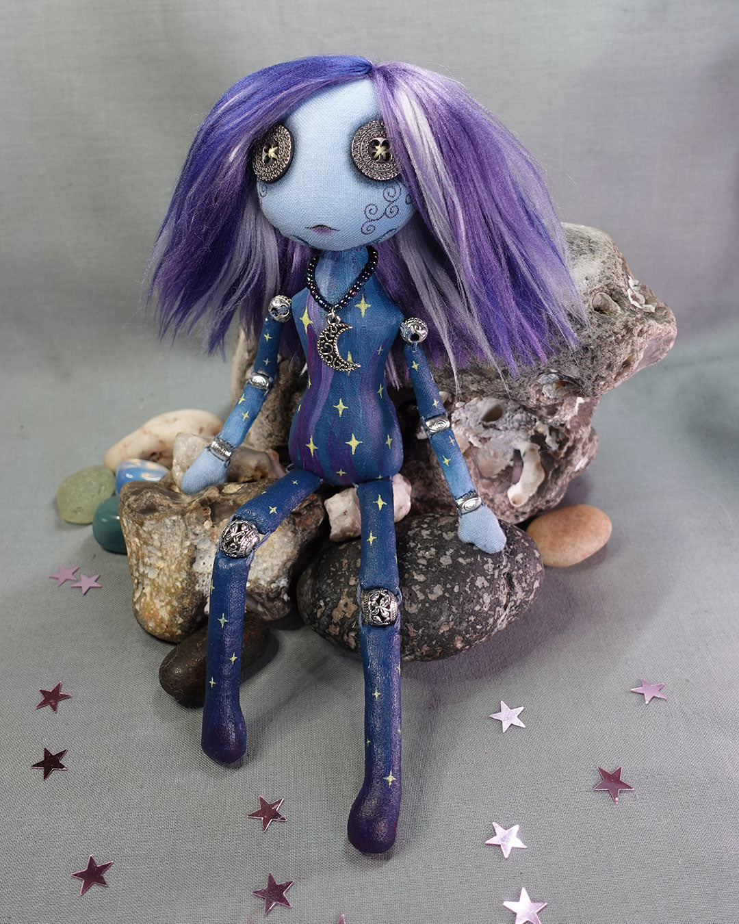 A bead jointed art doll painted as a starry sky in blues and purples