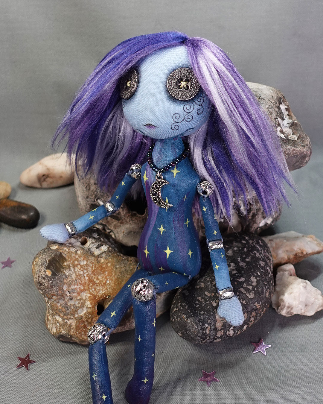 A bead jointed art doll painted as a starry sky in blues and purples