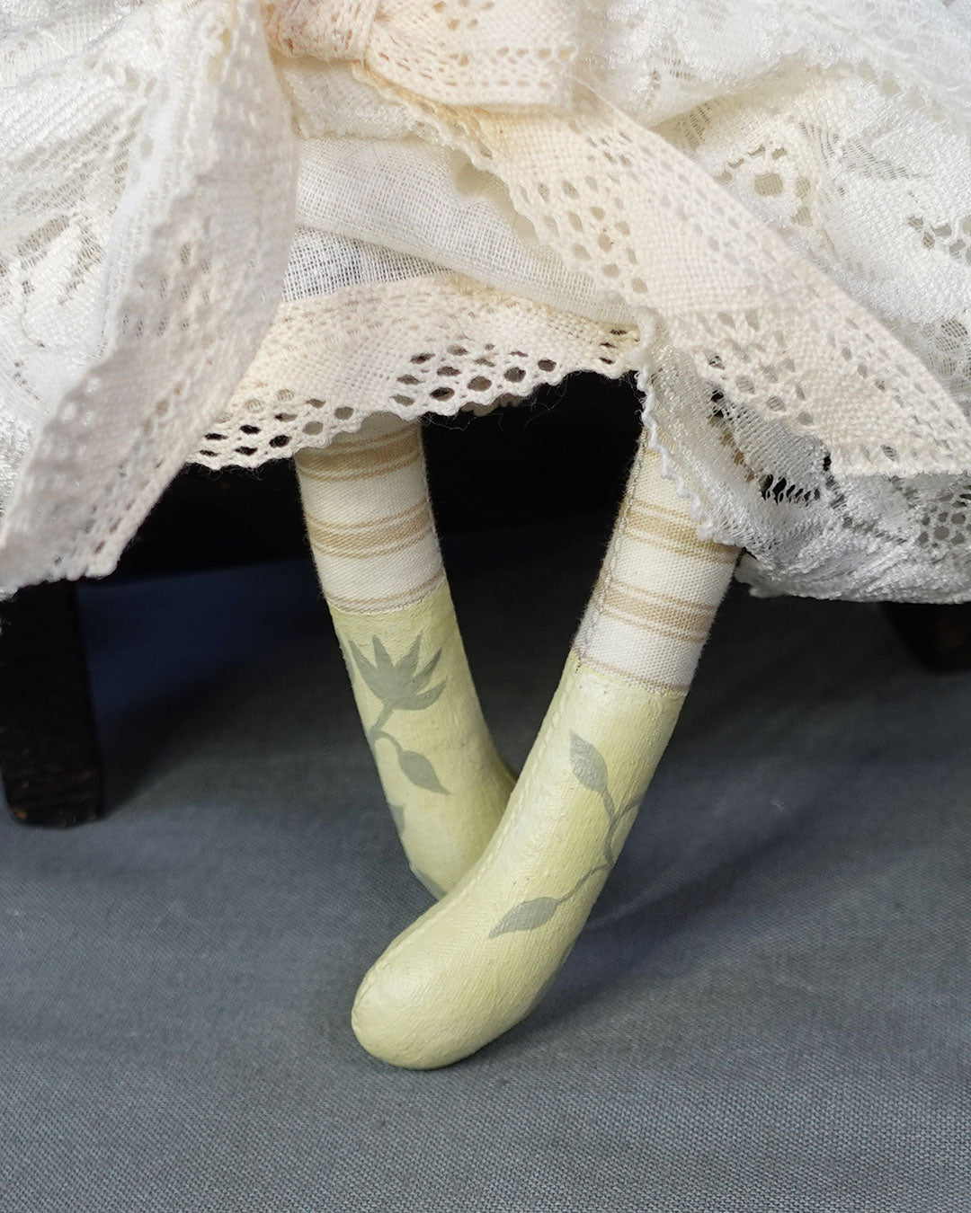 Close up of hand painted doll's boots and striped legs