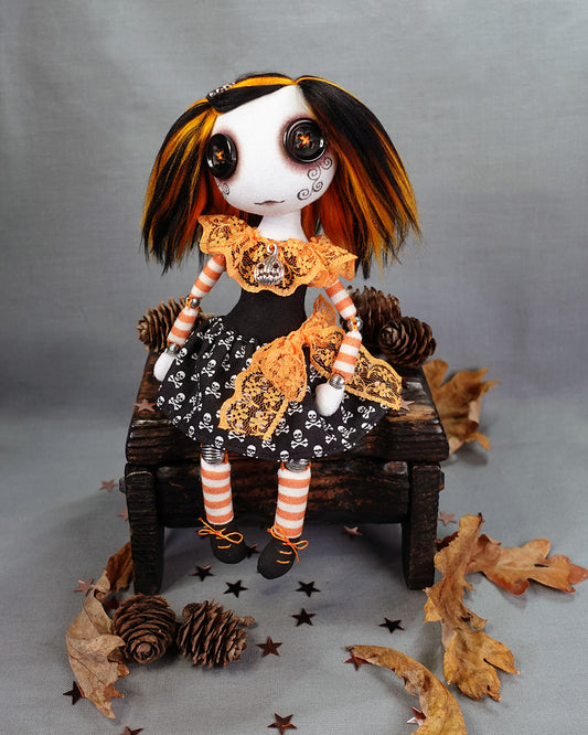 a halloween themed art doll with button eyes in orange and black