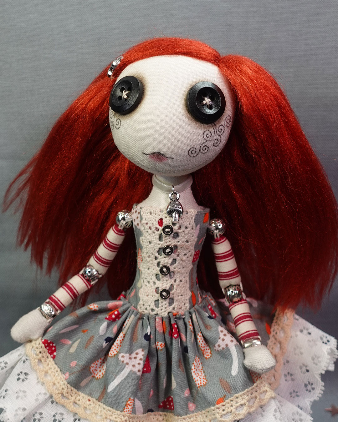 a button eyed cloth art doll with long red hair and mushroom print dress