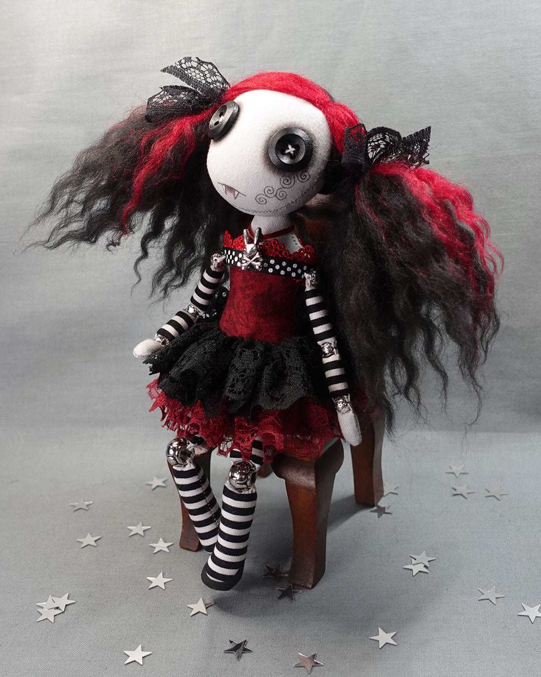 a button eyed cloth vampire doll in black and dark red