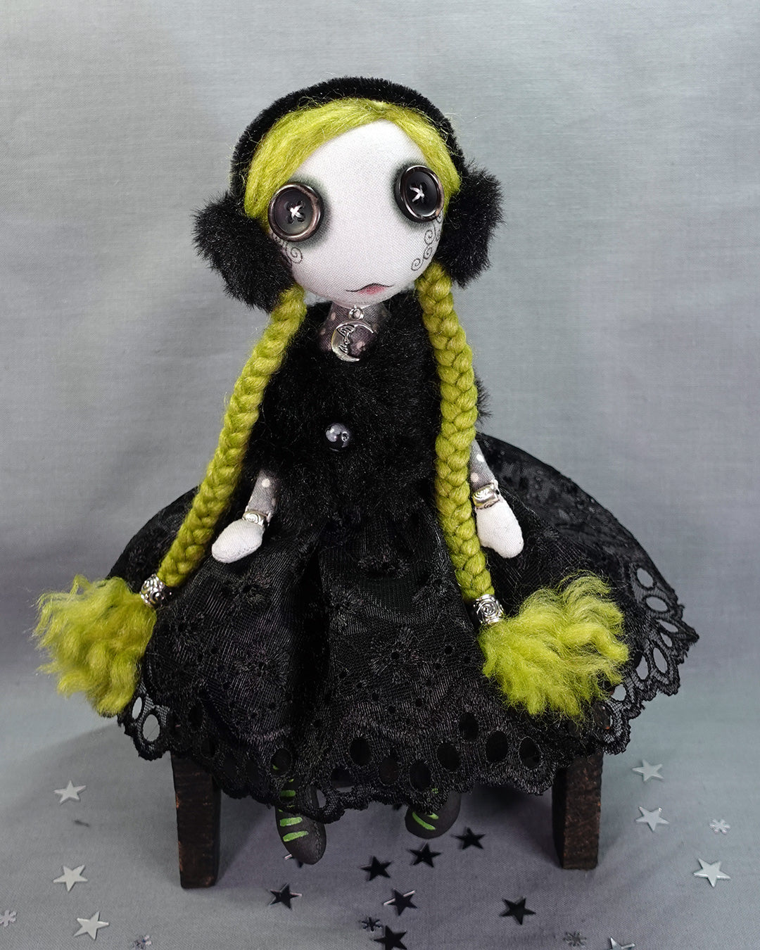a Goth winter art doll with green hair and faux fur wrap and earmuffs