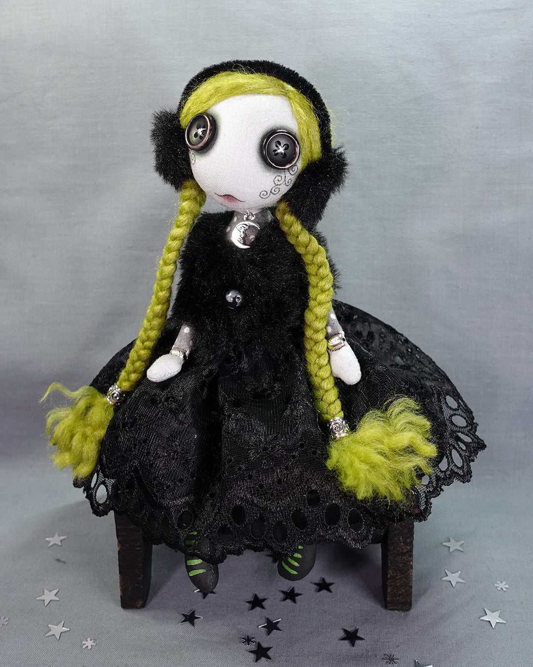 a Goth winter art doll with green braids and faux fur earmuffs