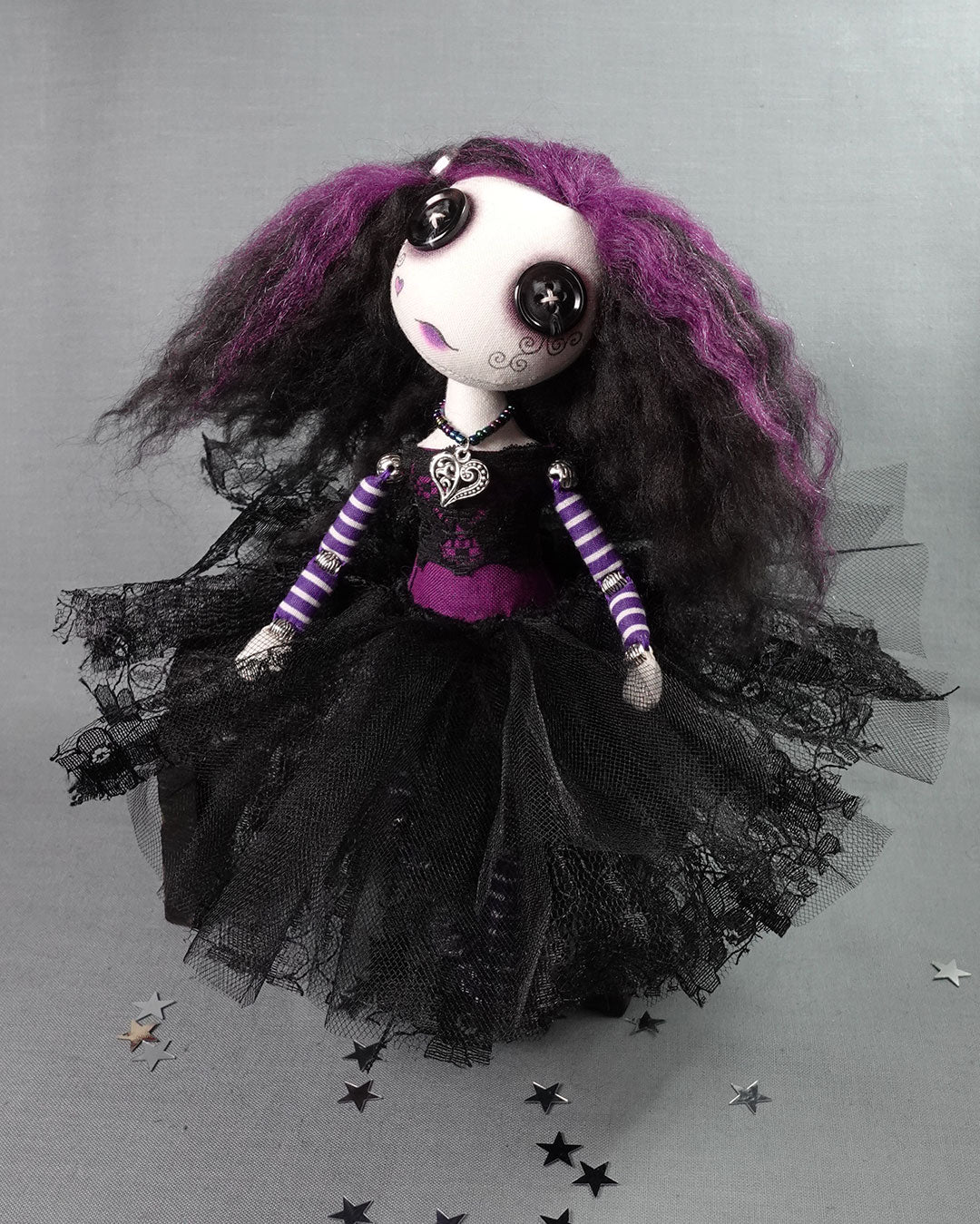 a button eyed gothic doll in purple and black