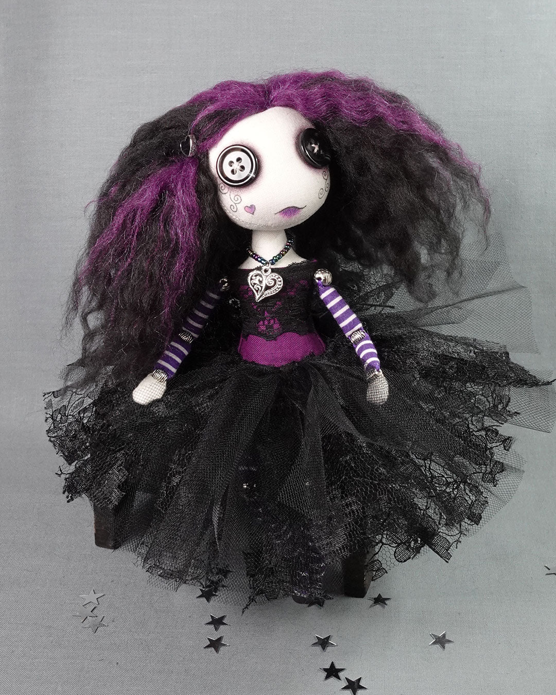 a button eyed gothic doll in purple and black