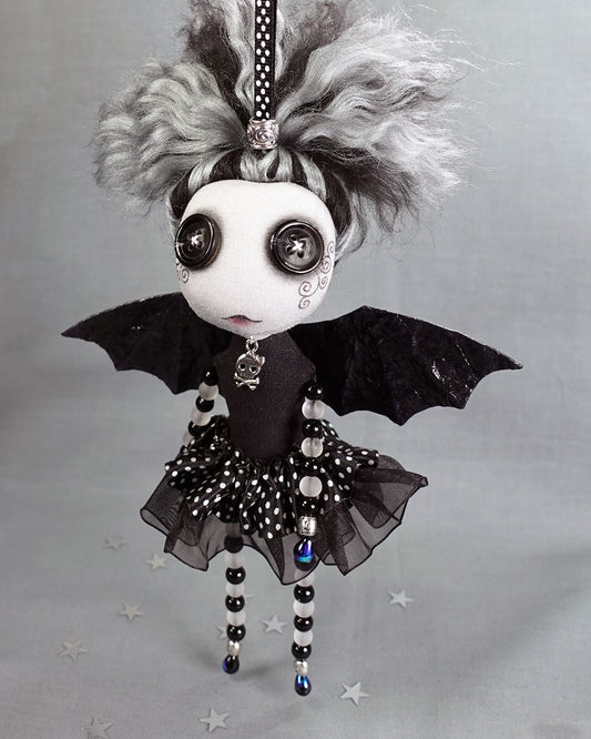 a Gothic fairy art doll with button eyes, bat wings and glass beaded arms and legs