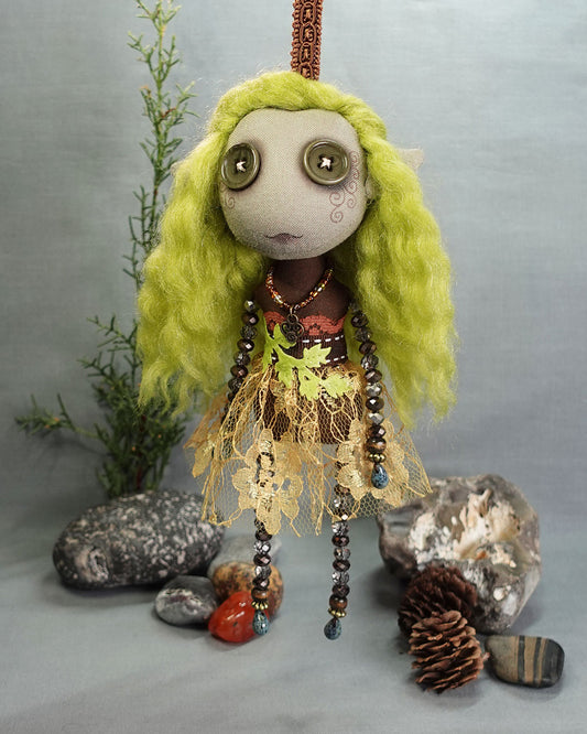 a hanging gnome art doll with button eyes in greens and browns