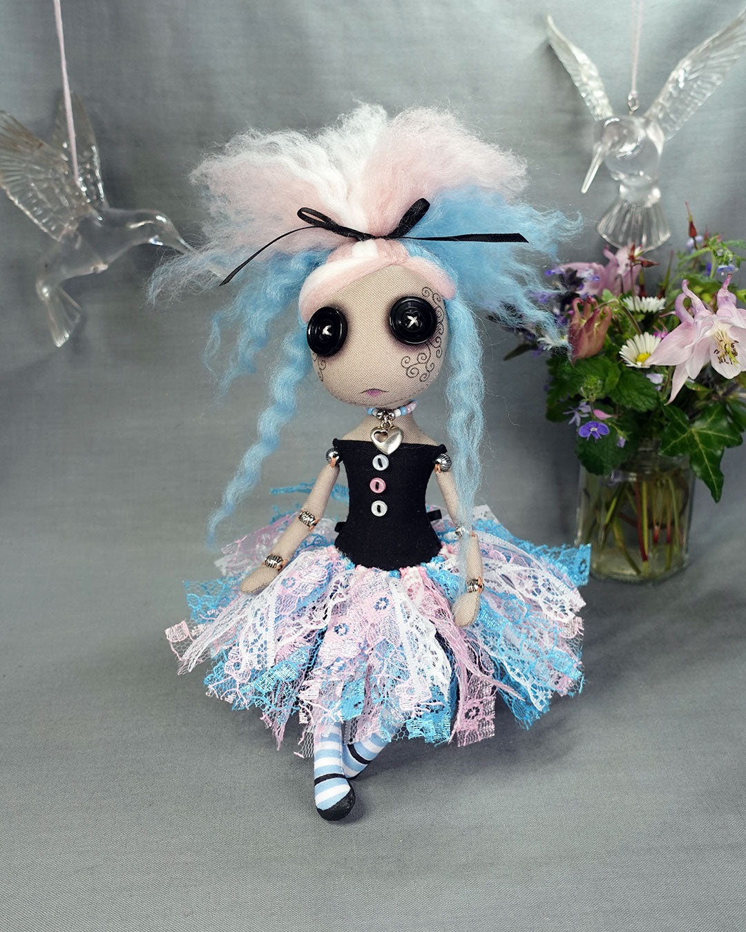 a button eyed cloth art doll in trans flag colours