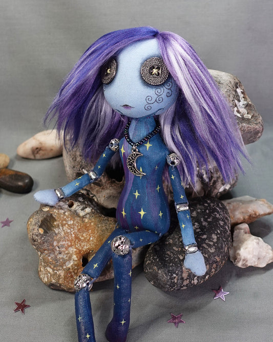 A bead jointed art doll painted as a starry sky in blues and purples