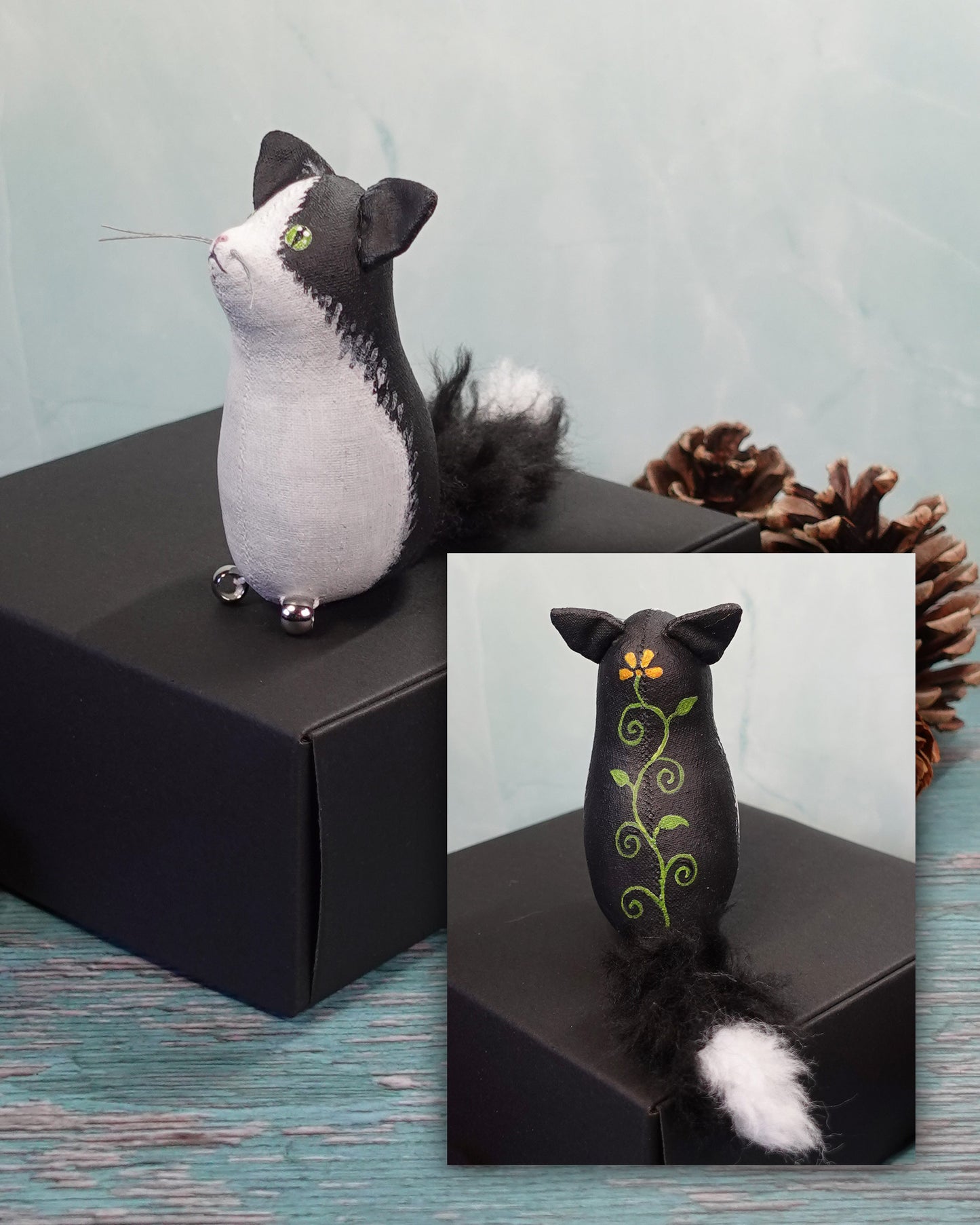Black and white cat figurine on a black box with a close-up inset showing flower painting on back.