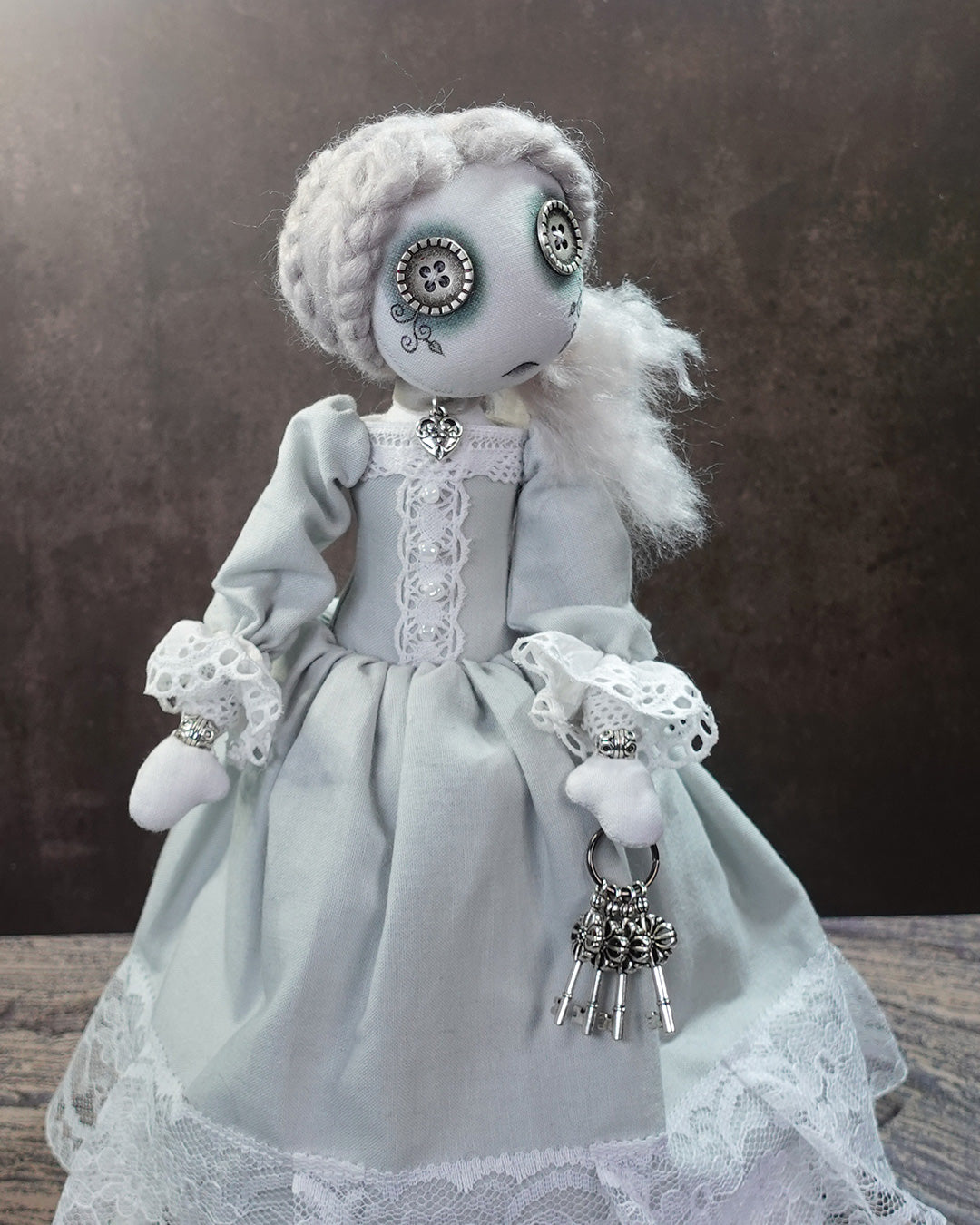 close up of victorian ghost themed art doll holding decorative keys