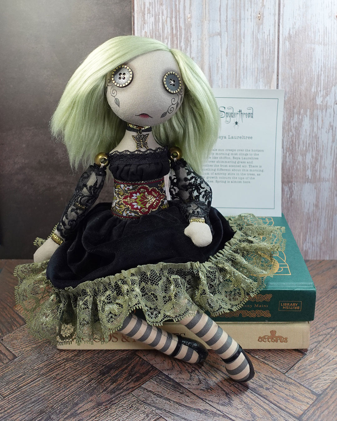 Art doll with green hair and intricate clothing with story card in background