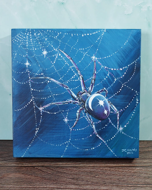 a square painting of a spider with moon and stars on its back in glistening web on blue background