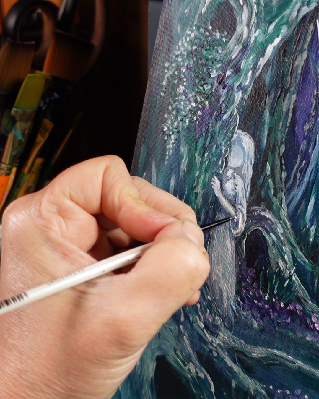 Artist's hand painting a ghost girl with fine brush