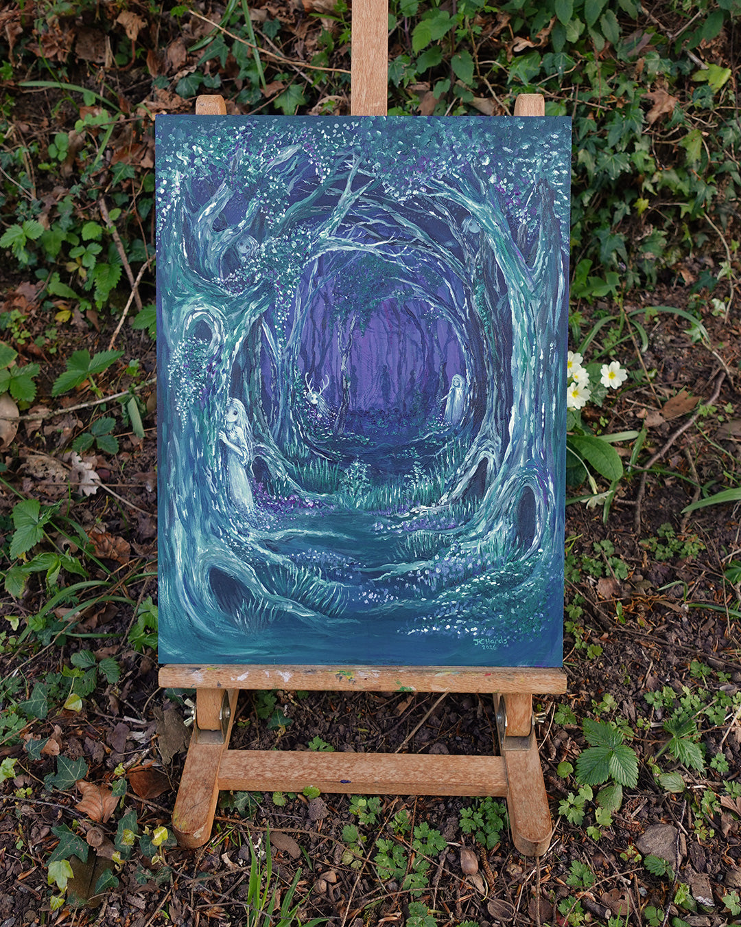 Mystical forest painting on wooden easel outdoors with ivy, brambles and primroses
